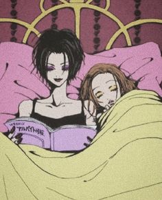 two women laying in bed reading a book