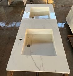 three white sinks sitting on top of a counter in a room with no one around them