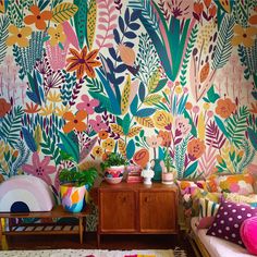 a living room with colorful wallpaper and furniture