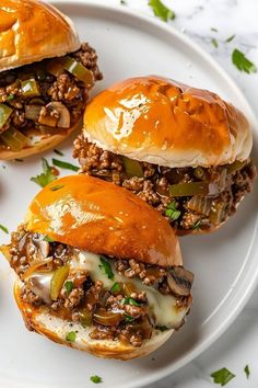 three sloppy joe sandwiches on a white plate