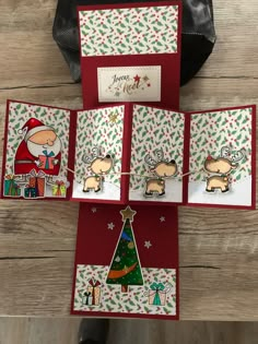 four christmas cards on a wooden table with a bag in the background and a handmade card