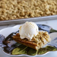 a piece of cake with ice cream on top is sitting on a plate next to a baking pan