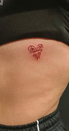 a woman's stomach with the words trust one written on her lower back side