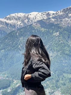 a woman standing on top of a mountain looking at the mountains