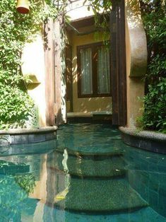 an outdoor swimming pool with steps leading up to the door and windows in the background