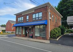 an empty building with a blue awning on the front and side of it's windows