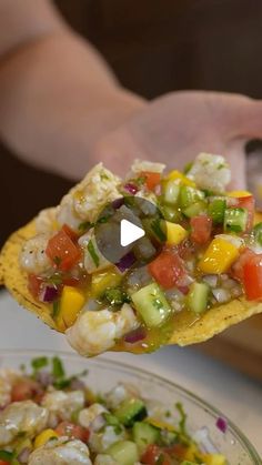 a person holding a tortilla with shrimp and vegetables