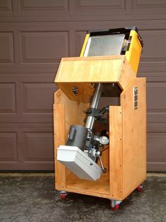 a small wooden cart with a computer on it's top and a camera in the middle