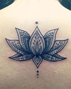 a woman's back with a lotus tattoo on it