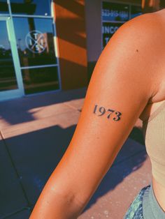 a woman's arm with the number thirteen tattoo on her left arm and numbers tattooed on it