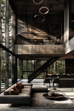 a living room filled with furniture and lots of windows next to a stair leading up to a loft