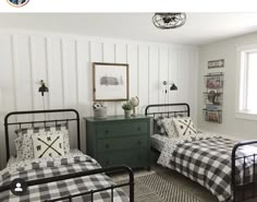 two black and white beds in a bedroom with plaid comforters on the bedding