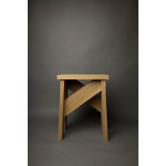 a small wooden table sitting on top of a gray floor