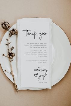 a white plate topped with a napkin next to a dried plant and a thank you note