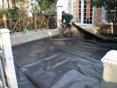 a man working on an inflatable pool with a water hose attached to it