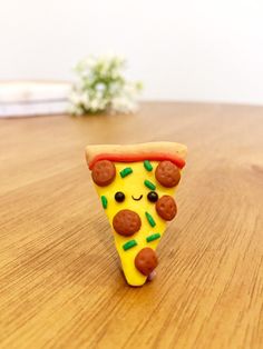 a slice of pizza with toppings on it sitting on top of a wooden table