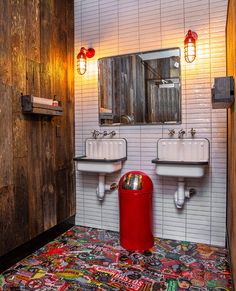 a bathroom with two sinks and a trash can