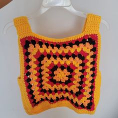 a crocheted square is hanging on a hanger