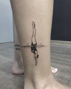 a woman's leg with a tattoo on it that has a person doing a handstand