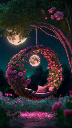 the moon is shining brightly in the night sky with pink flowers hanging from it's branches