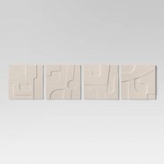 three pieces of art that are in the shape of square shapes on a white wall