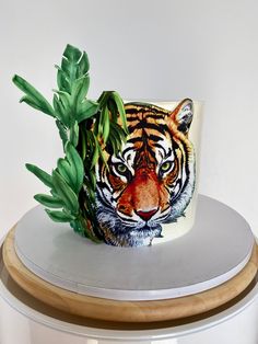 a ceramic tiger mug sitting on top of a wooden table next to a potted plant