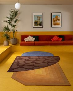 a living room filled with furniture and pictures on the wall above it's colorful carpet