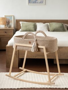 a wicker baby's cradle on a rug in front of a wooden bed