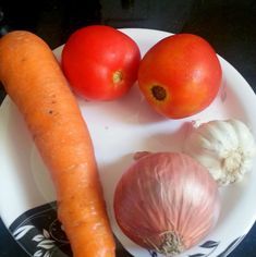 carrots, onions and tomatoes are on a plate