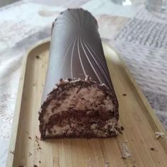 a piece of chocolate cake sitting on top of a wooden tray