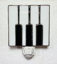 a white and black wall mounted light with four lights on it's back side