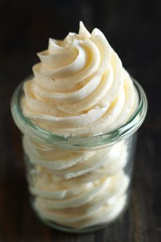 a glass bowl filled with whipped cream on top of a table