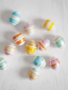 an assortment of painted easter eggs on a white surface