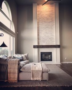 a living room filled with furniture and a fire place next to a large open window