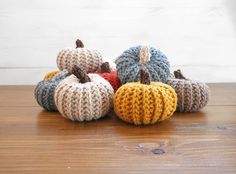 several knitted pumpkins sitting on top of a wooden table