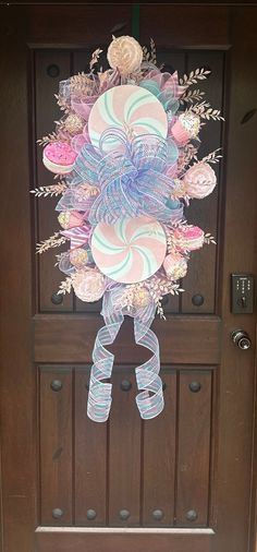 the door is decorated with candy canes and flowers in pastel colors, as well as an ornament