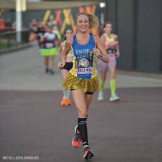 a woman running in a marathon wearing a gold skirt