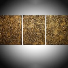 three pieces of gold paint on a white background, each with different shapes and sizes