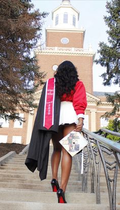 a woman is walking up some stairs with her graduation gown on and she is wearing high heels