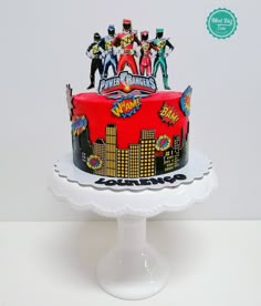 a birthday cake decorated with the theme of the show's logo and superheros