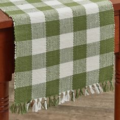 a green and white checkered table cloth on a wooden table with wood legs,