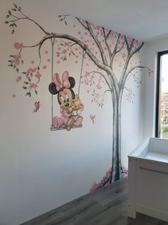 a child's room painted in pink and white with mickey mouse on the swing