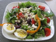 a white plate topped with salad and hard boiled eggs