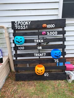 a wooden pallet with halloween decorations on it and the words spooky toss trick or treat