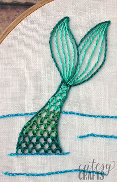 a hand embroidered mermaid tail on a hoop