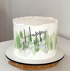 a birthday cake with green and white frosting on a wooden platter that says happy birthday