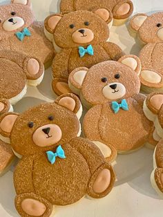 there are many teddy bears made out of sugar cookies on the table with blue bow ties