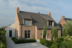 a large brick house surrounded by greenery