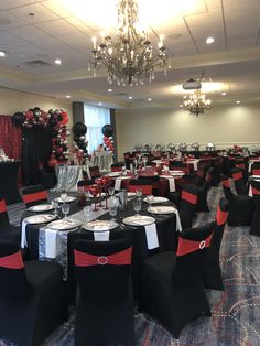 a banquet room set up with black and red linens