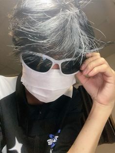 a person with sunglasses and a mask covering their face